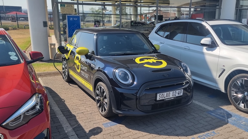 The Whale Coast Solar Mini Cooper SE charging at a BMW dealership