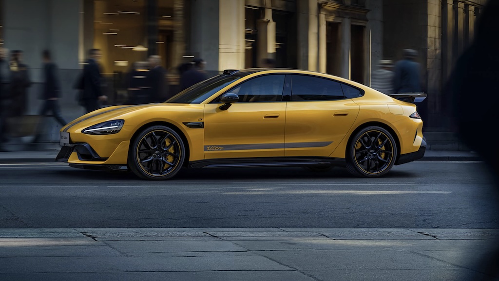 A profile shot of a yellow SU7 driving on a city street.
