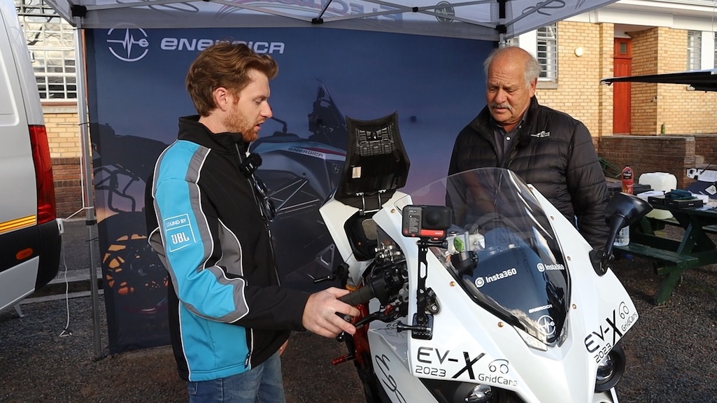 An Energica Ego electric motorcycle flanked by two men