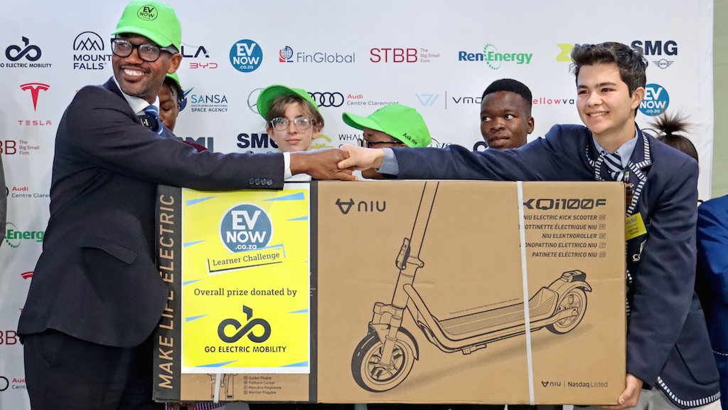 The mayor and the winner holding the Niu scooter from GoElectric