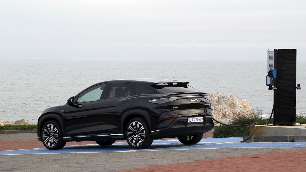 Black BYD Sealion 7 plugged in, ocean in background